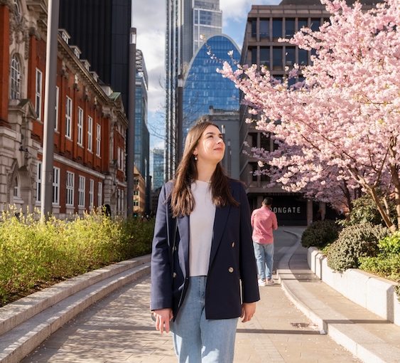 Woman walking through the City of London on a sunny day.