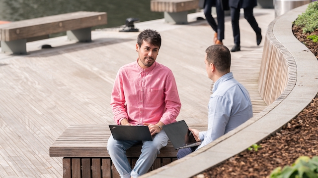Two men working on laptops in Canary Wharf, London.