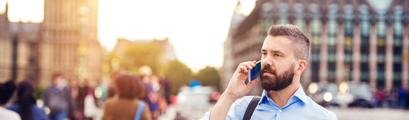 A man speaking on a mobile phone with Westminster in the background.