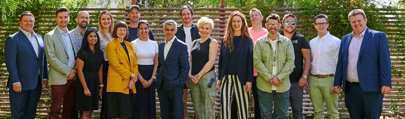 A group of people pose together and smile while attending a business event