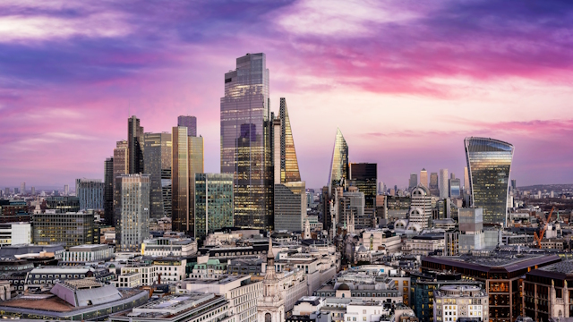 City of London skyline with skyscrapers and purple-hued sky.