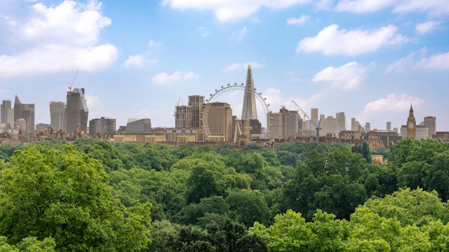 London skyline featuring London Eye, The Shard and Big Ben, with park in foreground.