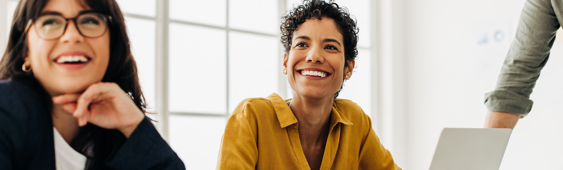 Two women smiling in a boardroom meeting