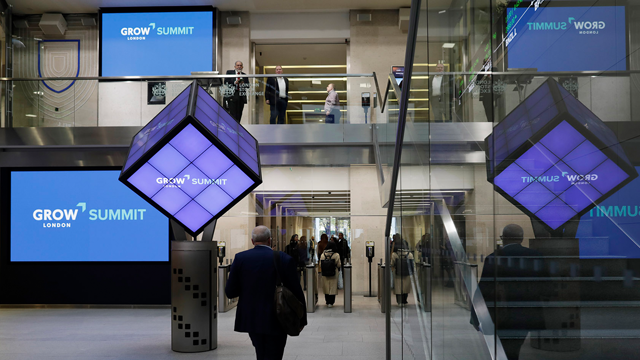 A building lobby with GROW Summit branded blue and purple luminous decorations.