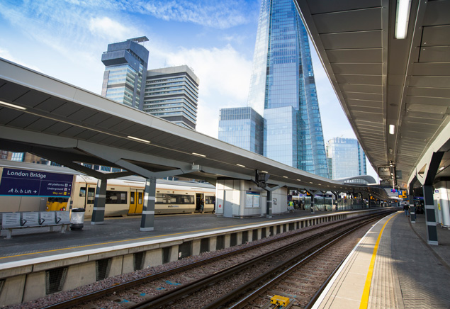A view of a platform in London Bridge station with skyscrapers in the background. 