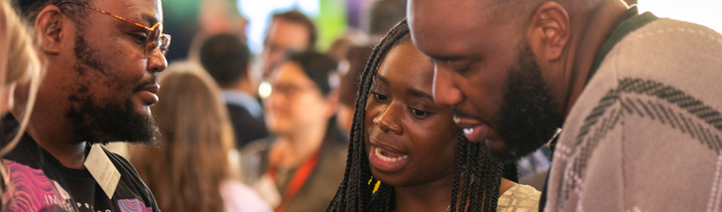 Three people talking during a business networking event.