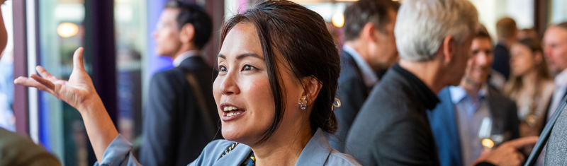 A woman speaking with a man during a business networking event.