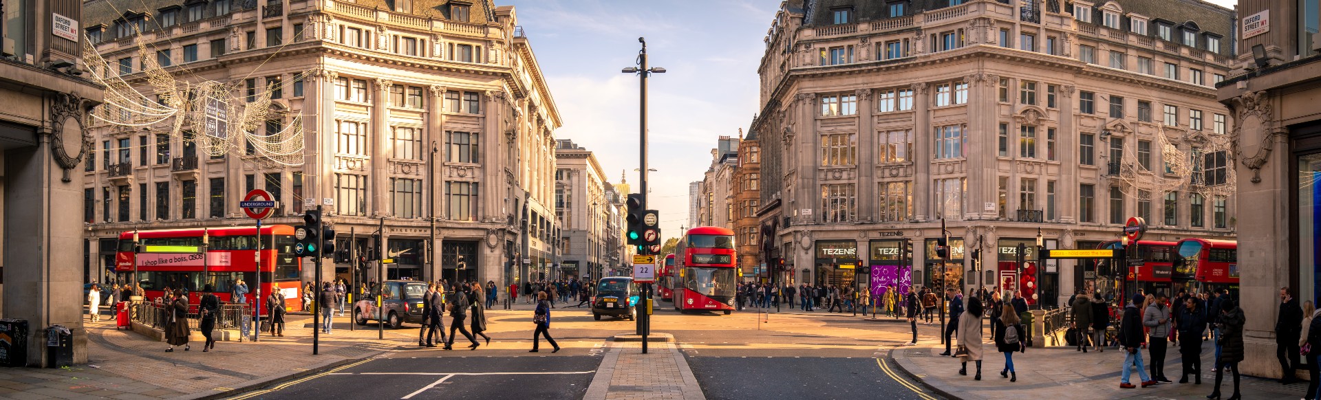 People enjoy the shops on London's Oxford Street during golden hour. 