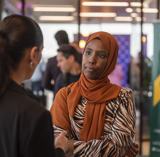 Two women talking at a business event