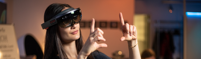 A woman using a virtual reality headset and making gestures with  her hands.
