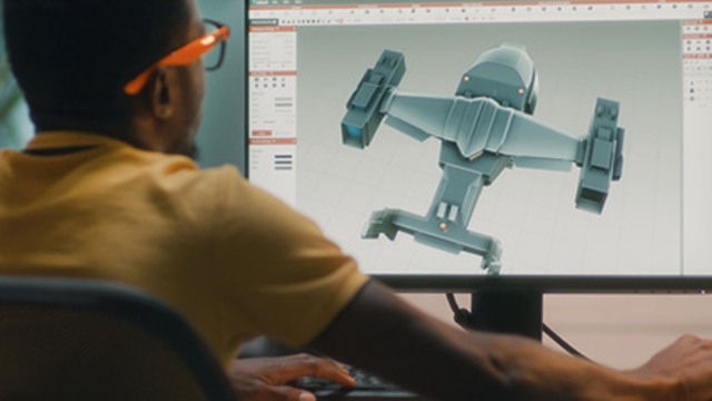 A man using a computer sitting with his back to the camera