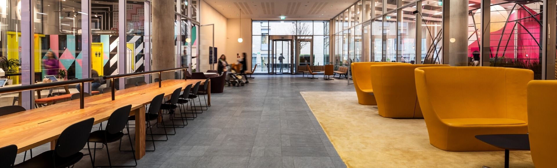Big office space with a long wooden desk to the left and big chairs to the right.