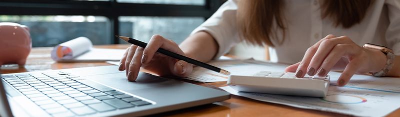 Businesswoman using a laptop and calculator.
