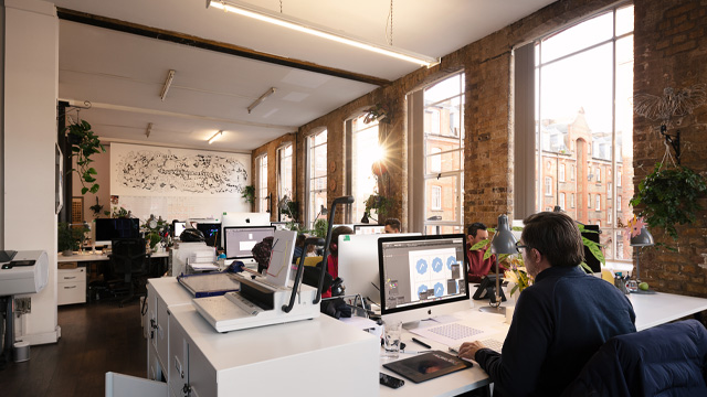 A view of a modern office space with people working on desktop computers. 