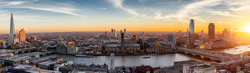 A wide angle view of the Tate Modern museum with the river Thames and London skyline.
